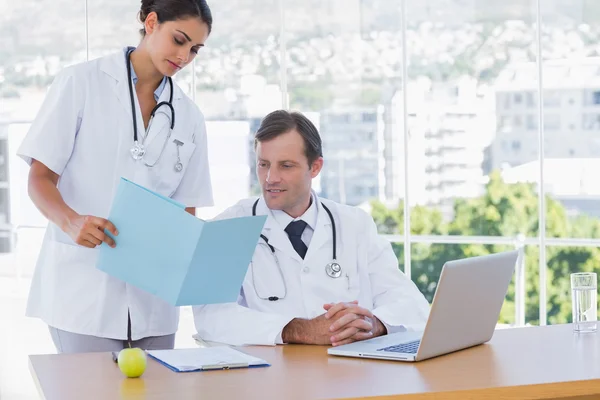 Doctor showing a folder to a colleague — Stock Photo, Image