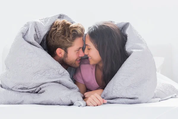 Casal envolto no edredom — Fotografia de Stock