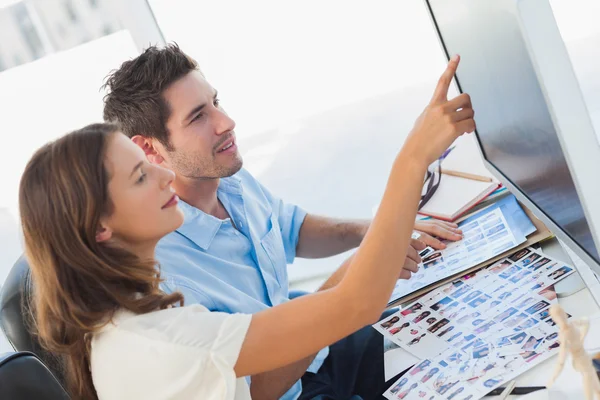 Young photo editors pointing at a computer screen — Stock Photo, Image