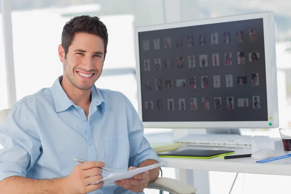 Handsome photo editor holding documents — Stock Photo, Image