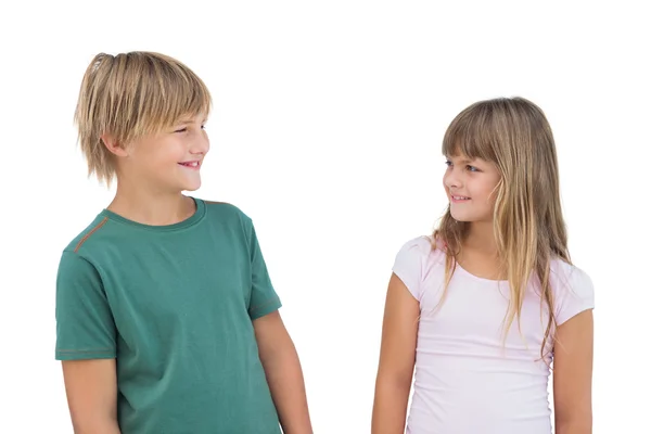 Klein meisje en jongen op zoek naar elkaar en glimlachen — Stockfoto