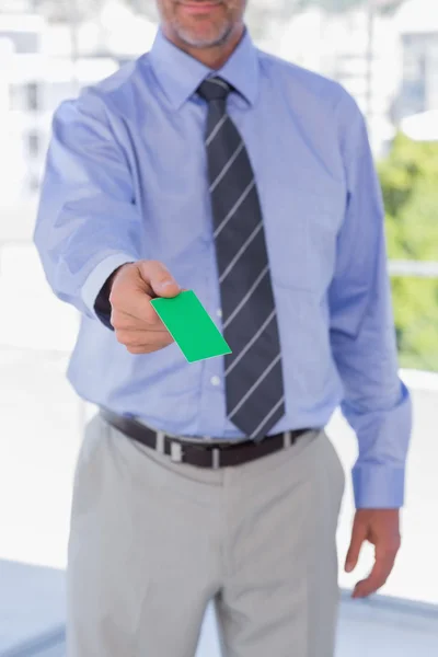 Geschäftsmann gibt grüne Visitenkarte ab — Stockfoto