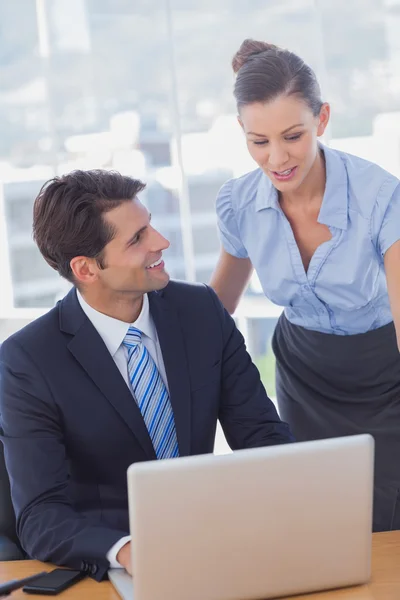 Affari felici lavorando insieme con un computer portatile e sorridendo — Foto Stock