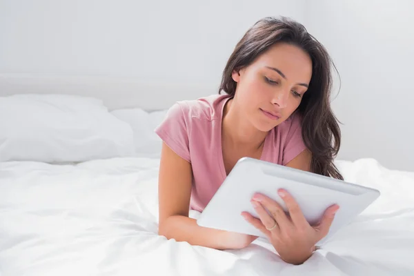 Mulher usando um tablet em sua cama — Fotografia de Stock