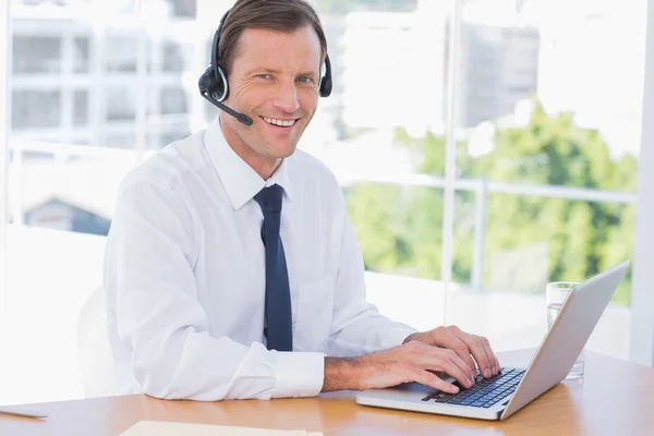 Hombre de negocios alegre con un auricular —  Fotos de Stock