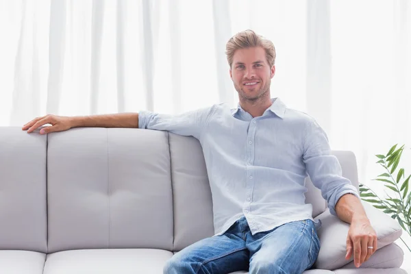 Мужчина сидел на диване в гостиной — стоковое фото