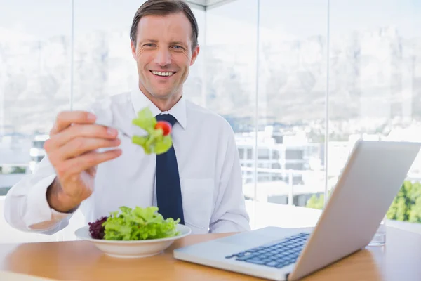 Uomo d'affari sorridente mangiare un'insalata — Foto Stock