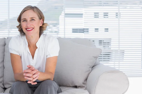 Blonde Geschäftsfrau sitzt auf Couch — Stockfoto