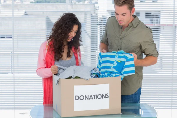 Zwei Freiwillige holen Kleidung aus einer Spendenbox — Stockfoto