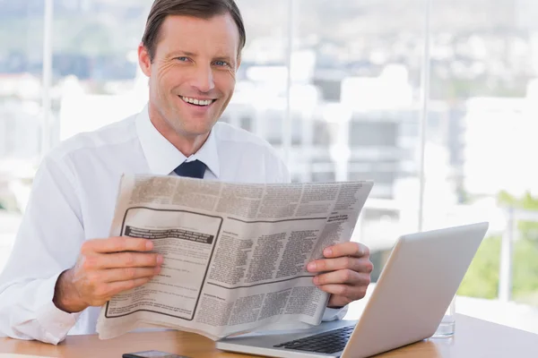 Empresário alegre lendo um jornal — Fotografia de Stock