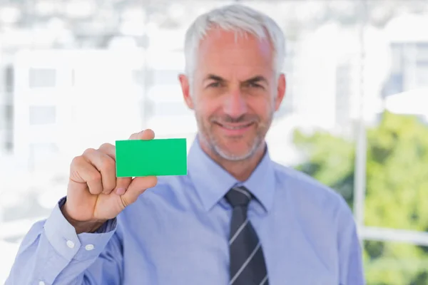 Feliz hombre de negocios mostrando tarjeta de visita verde — Foto de Stock