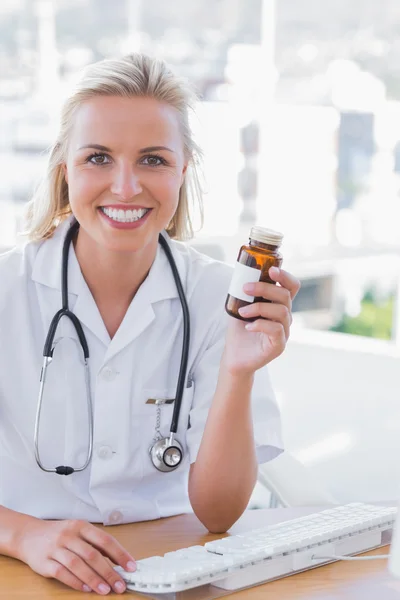 Smiling nurse holding a medicine jar — Stock Photo, Image