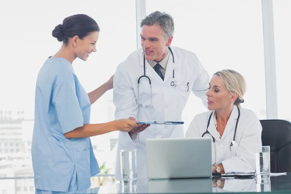 Nurse giving folder to her colleagues — Stock Photo, Image