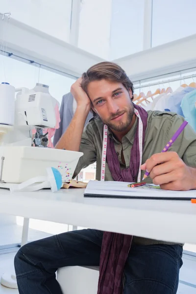 Attractive fashion designer working at his desk — Stock Photo, Image