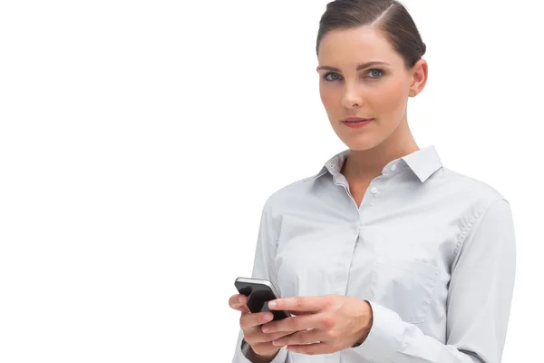 Serious businesswoman holding cellphone — Stock Photo, Image