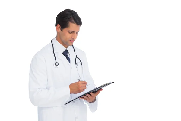 Smiling doctor holding pen and clipboard — Stock Photo, Image