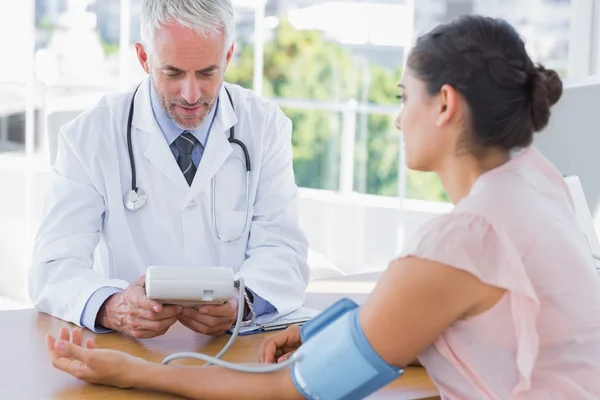 Médico midiendo la presión arterial de un paciente — Foto de Stock