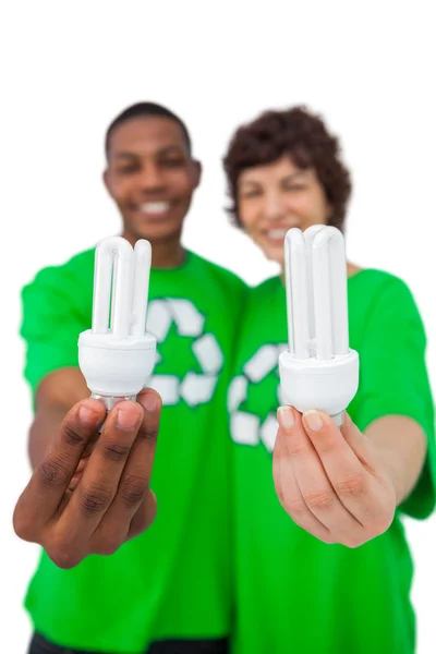 Environmental activists showing energy saving light bulbs — Stock Photo, Image