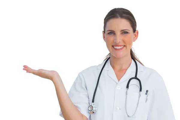 Glad sjuksköterska visar något och ler — Stockfoto