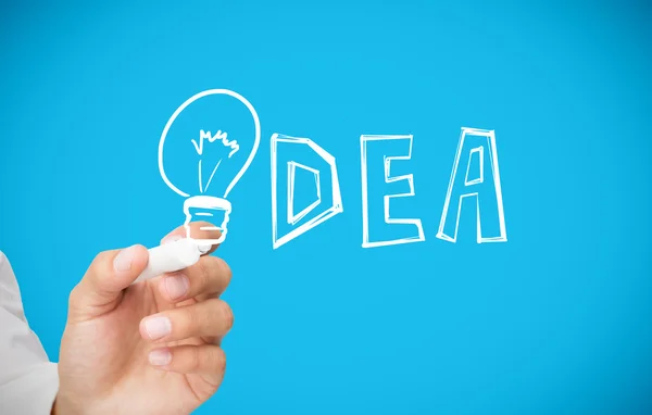 Businessman drawing light bulb as the i in idea — Stock Photo, Image