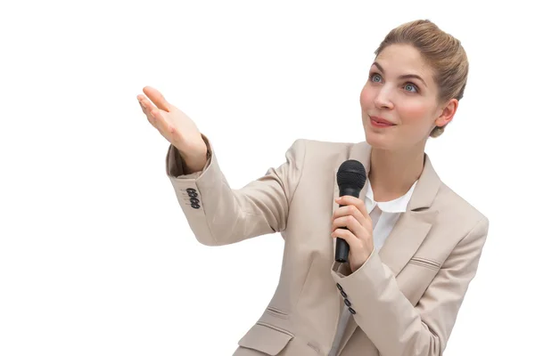 Businesswoman with microphone pointing at something — Stock Photo, Image