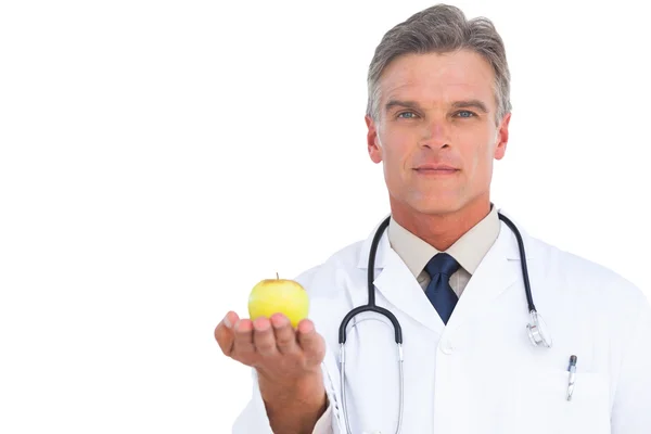 Doctor showing green apple — Stock Photo, Image