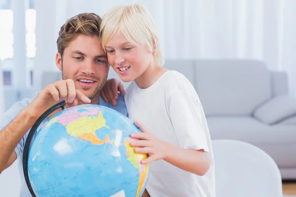 Pai e seu filho olhando para o globo — Fotografia de Stock