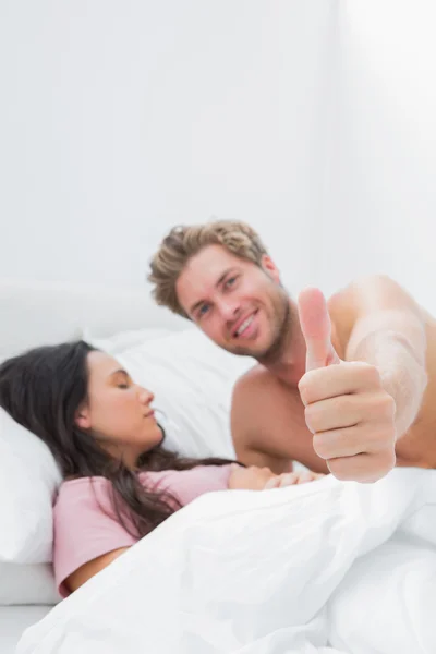 Hombre dando el pulgar al lado de su compañero de dormir —  Fotos de Stock