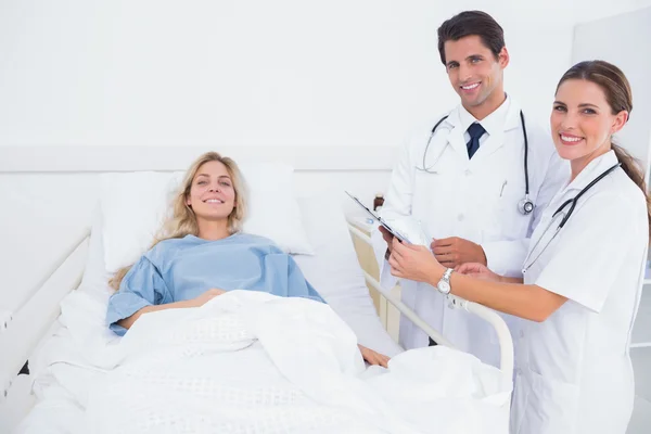 Smiling patient and doctors — Stock Photo, Image