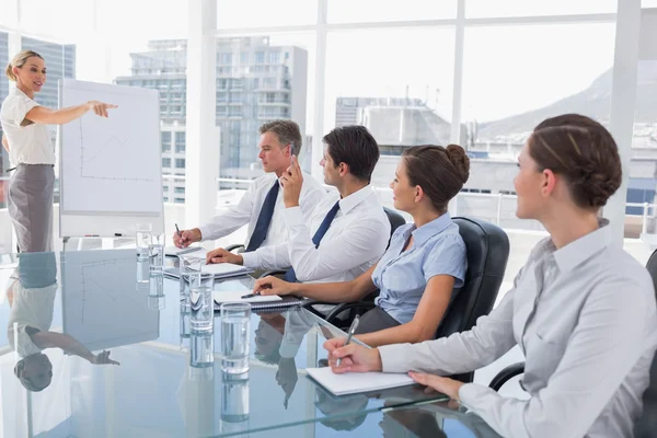 Zakenvrouw wijzend op een collega die iets vraagt — Stockfoto