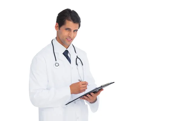 Young doctor holding a clipboard and pen — Stock Photo, Image