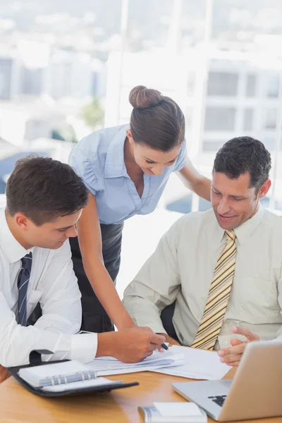 Smiling business working together on a document Stock Image