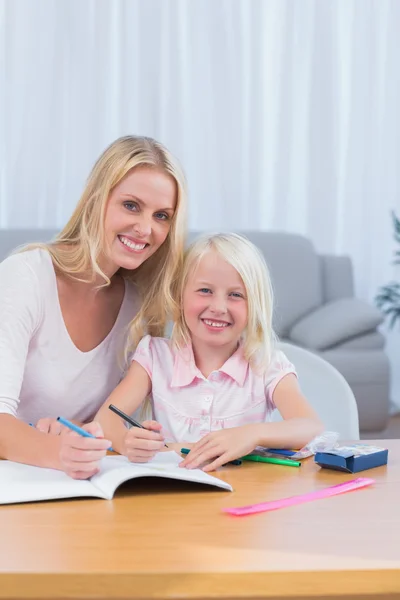 Smiling mother and daughter drawing together Royalty Free Stock Photos