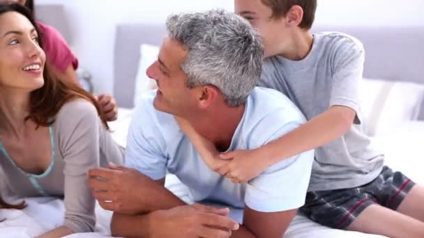 Pais e seus filhos brincando na cama — Vídeo de Stock