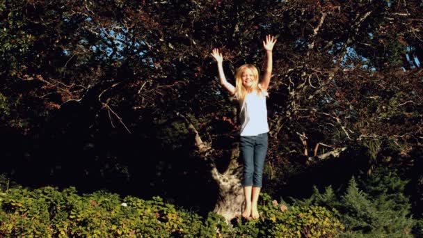 Wesoła blondynka dziewczynka skoki na trampolinie — Wideo stockowe
