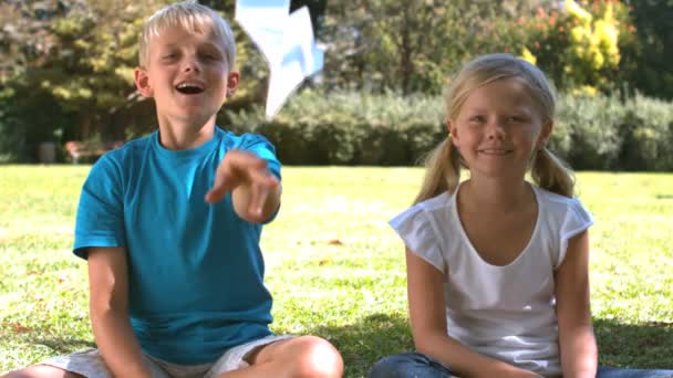 Hermano lanzando un avión de papel junto a su hermana — Vídeos de Stock