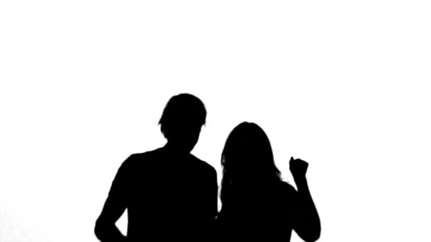 Silhouetten van paar verhogen hun armen op witte achtergrond — Stockvideo