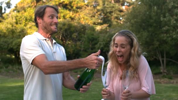 Handsome man opening a bottle of champagne — Stock Video