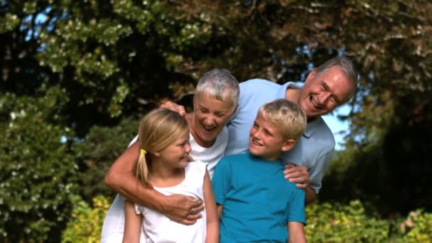 Веселая многодетная семья, обнимающаяся в парке — стоковое видео