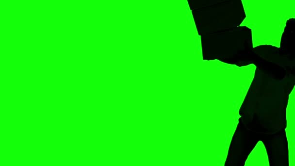 Силует незграбного чоловіка скидає коробки на зелений екран — стокове відео