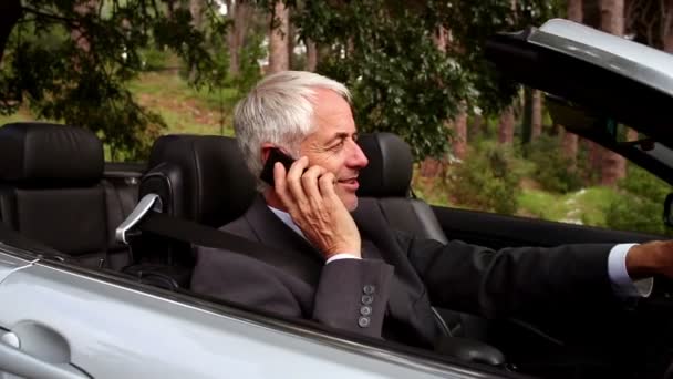 Happy businessman phoning in his convertible car — Stock Video