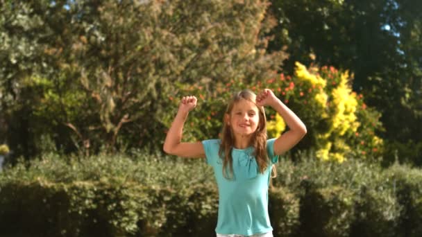 Menina bonito pulando em seu jardim — Vídeo de Stock