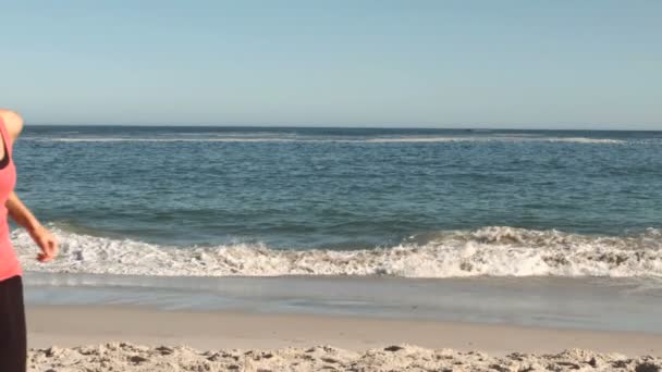Привлекательная женщина бегает по пляжу — стоковое видео