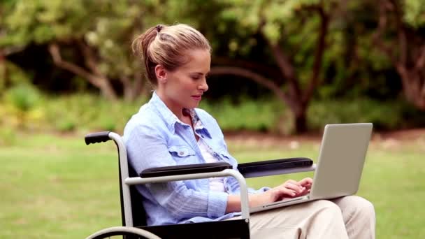 有吸引力的女人坐在轮椅上使用她的笔记本电脑 — 图库视频影像