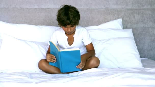 Child reading a book in bedroom — Stock Video