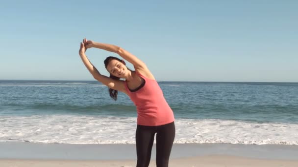 Attraktiv kvinna stretching på stranden — Stockvideo