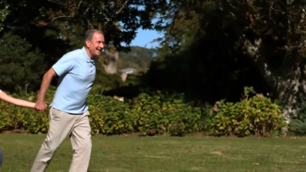 Nietos y abuelos corriendo de la mano en un parque — Vídeo de stock