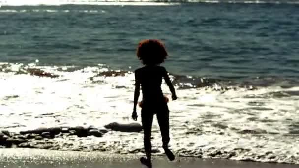 女子跳跃和提高的胳膊和腿在海 — 图库视频影像
