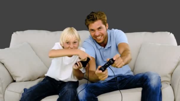 Pai e filho jogando videogames em fundo cinza — Vídeo de Stock