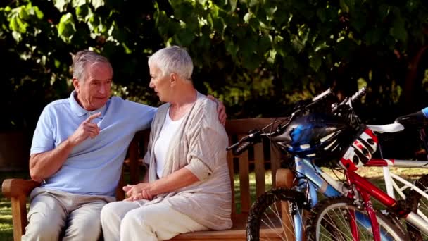 Зрелая пара разговаривает в парке — стоковое видео